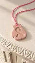 Dusty Pink Pendant on Carved Ivory Surface.webp